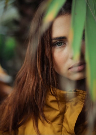 portrait image of a girl with leaves in front of her